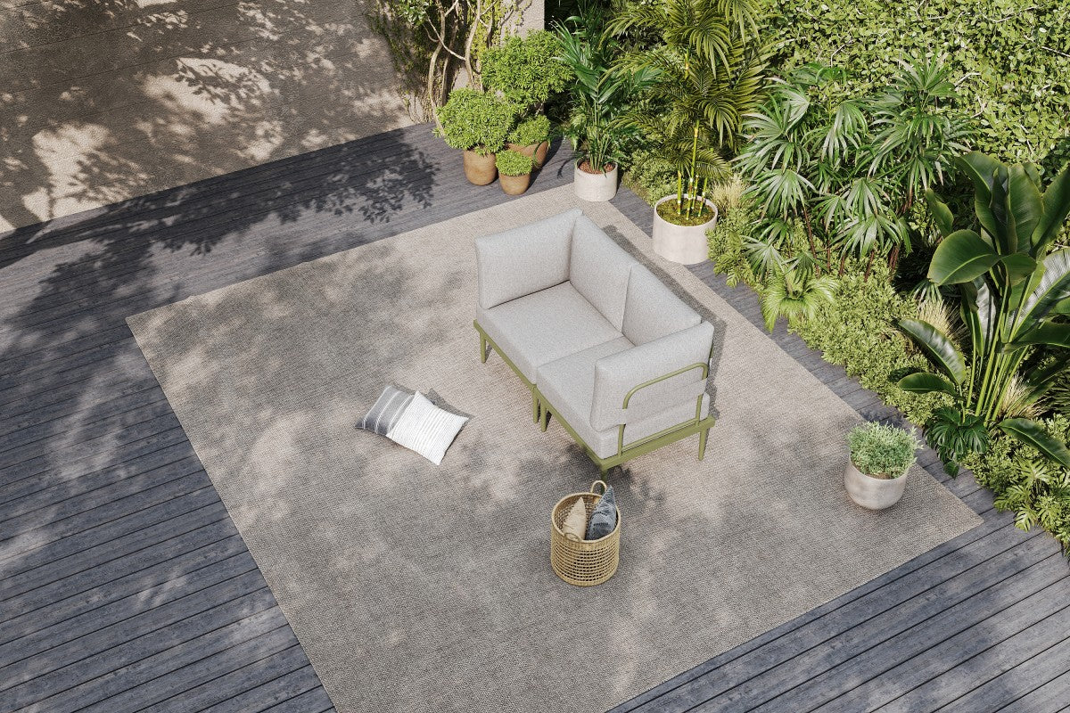 A corner patio furniture set with beige cushion placed on a outdoor patio with plants around.#color_green