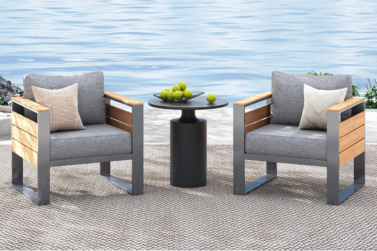 Two gray chairs with wooden finish armrests and a small round table with fruit on a textured surface.#color_gray