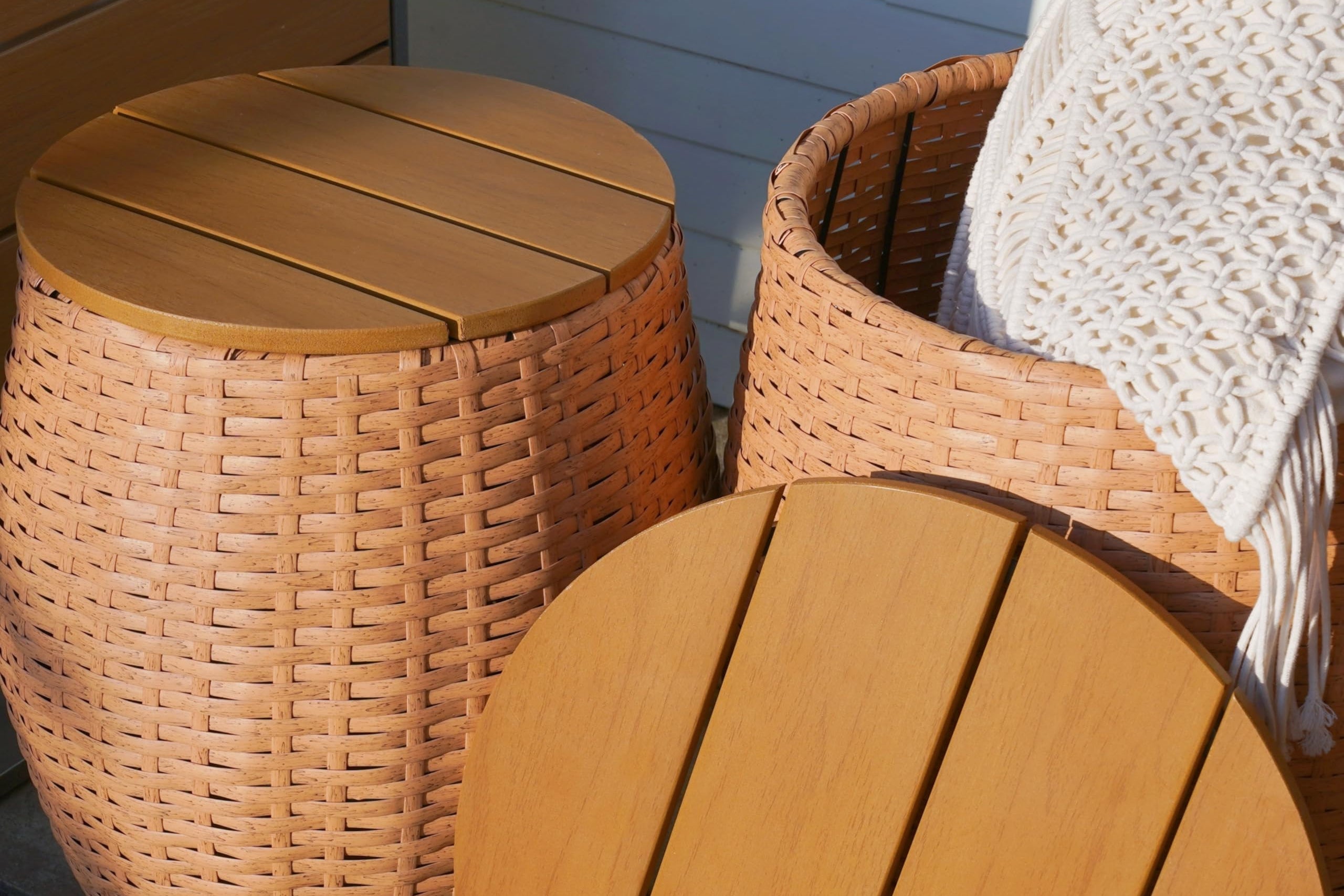 Wooden side table set with wicker stool on a deck, suitable for outdoor and indoor use.