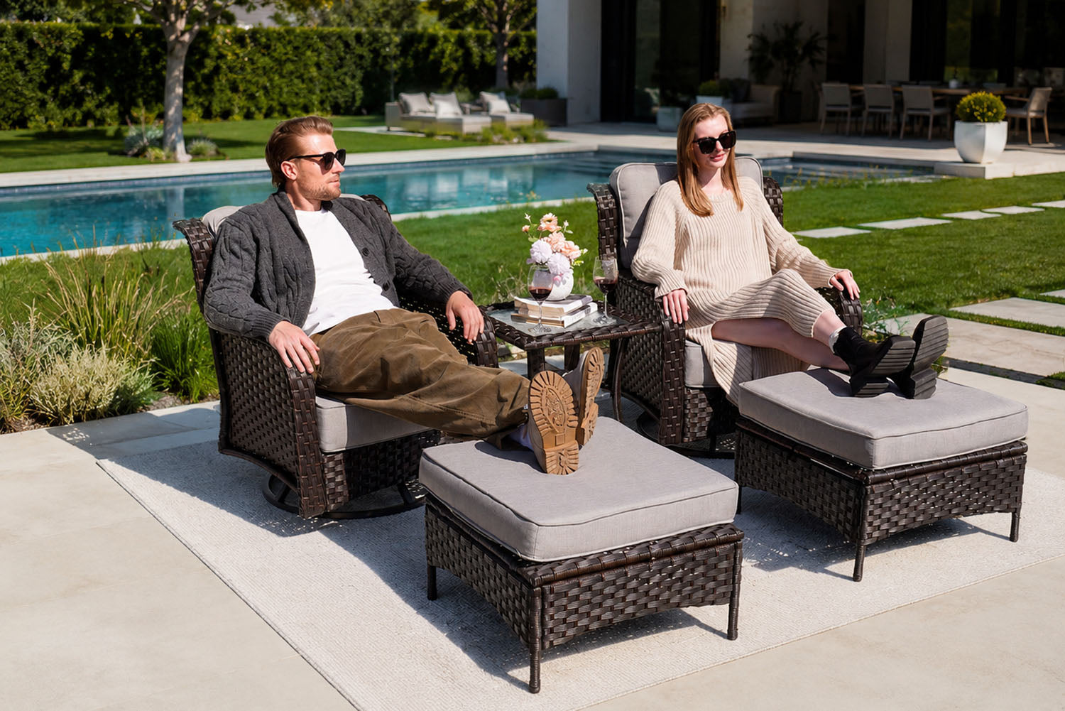 Two people sitting on outdoor furniture by a poolside.#color_gray