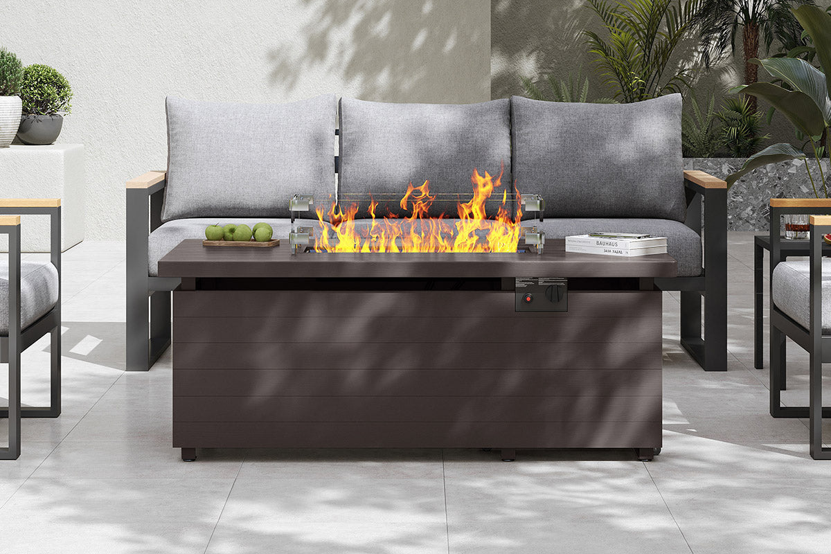 Outdoor patio with fire pit table and gray sofa.#color_brown