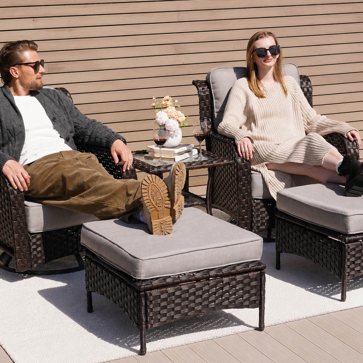a couple seating on the 2-Piece Outdoor Patio Wicker Ottomans with Cushions