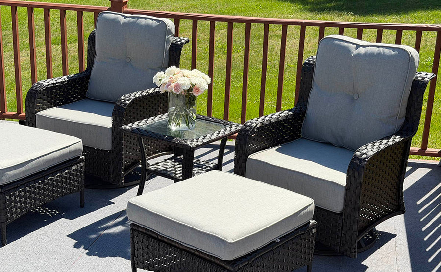 Outdoor patio furniture set with chairs, ottoman, and table on a deck.