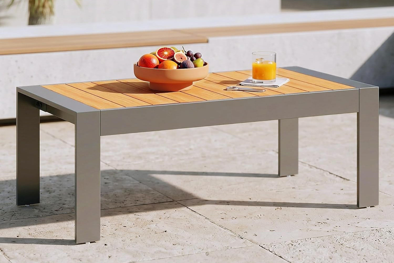 Outdoor table with fruit bowl and glass of juice on a patio