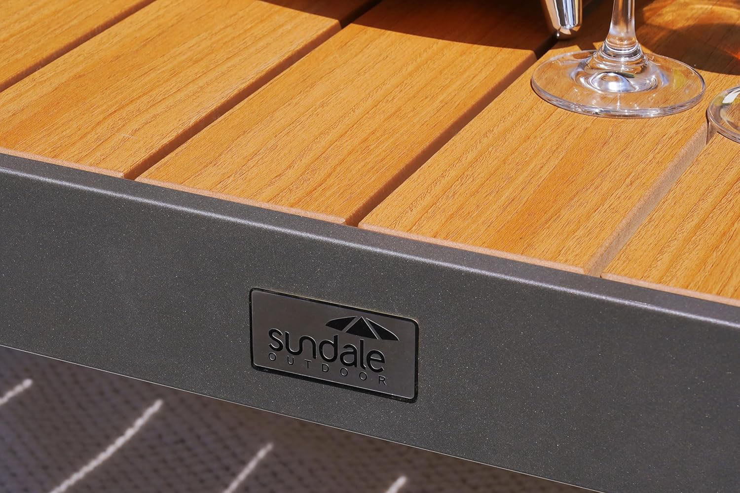 outdoor table with Sundale Outdoor logo and glasses on a blurred background