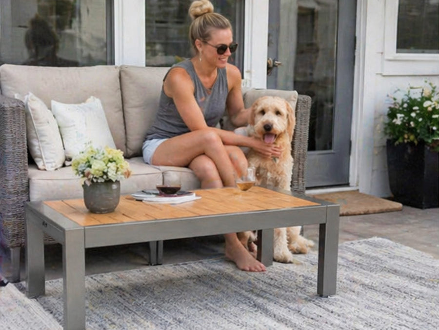 Woman sitting on a patio with a dog by a coffee table