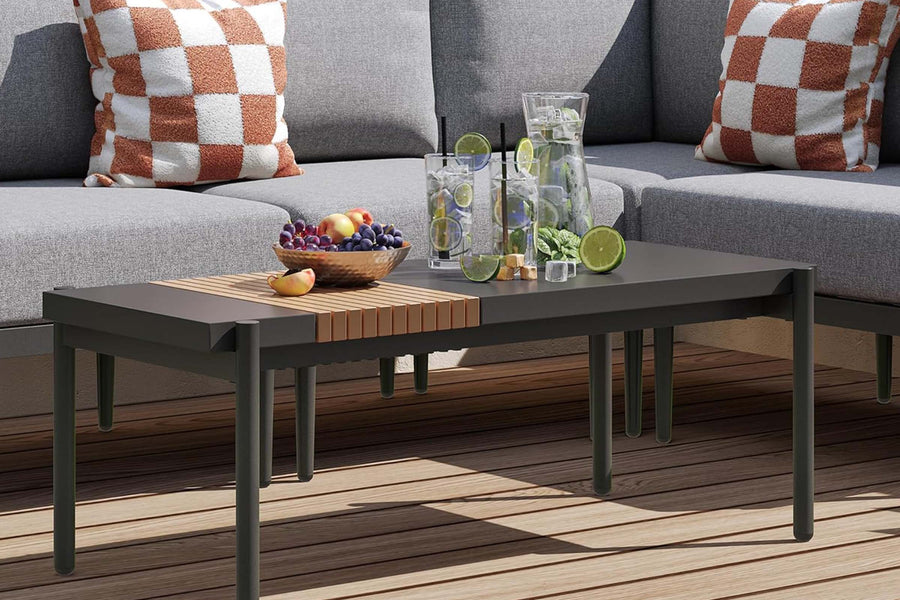 Outdoor setting with a coffee table, fruit bowl, and drinks on a wooden deck.#color_gray