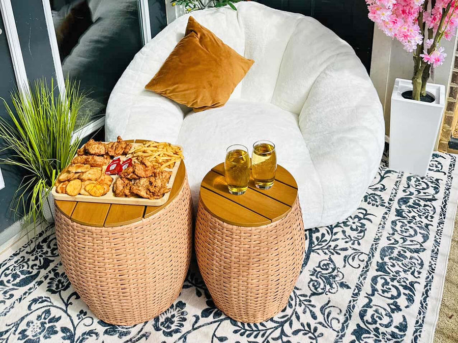 White bean bag chair with brown cushions, two small side tables, snacks, and drinks on a patterned rug.