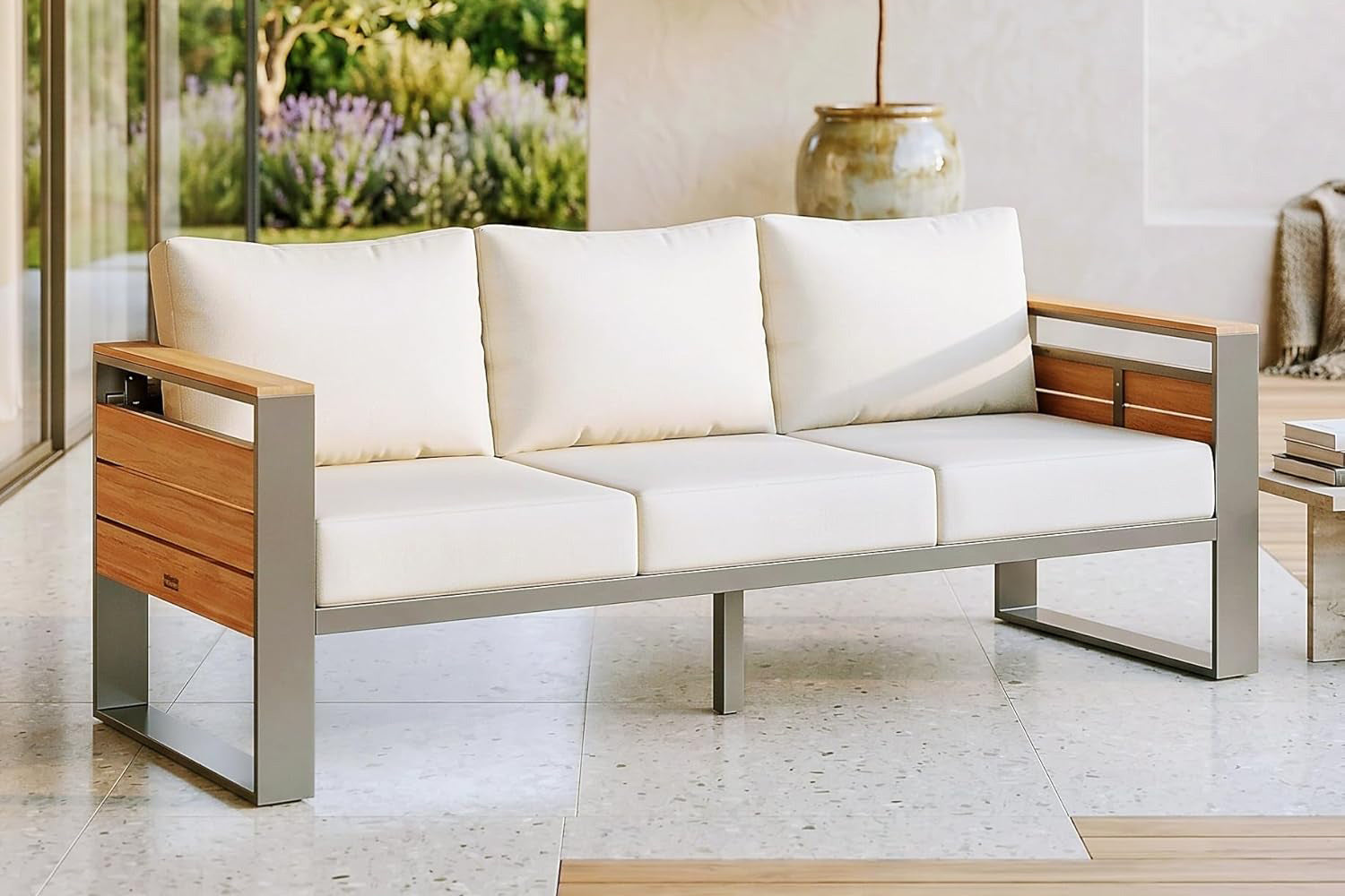 Modern outdoor sofa with white cushions and wooden armrests in a garden setting.#color_beige